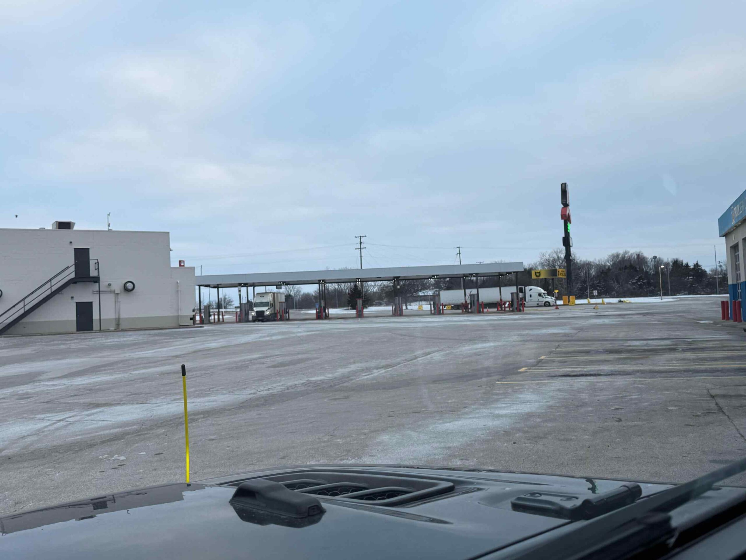 A large commercial parking lot cleared of snow and treated for ice on a winter day.